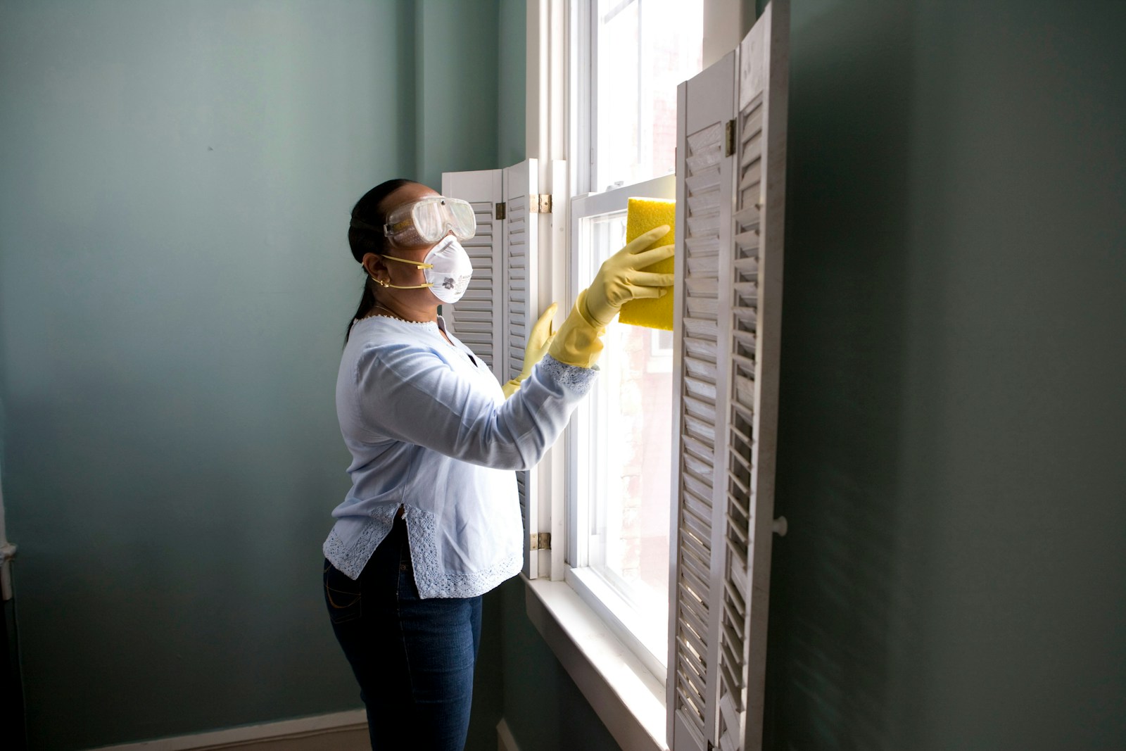 Professional cleaner wiping a bright window
